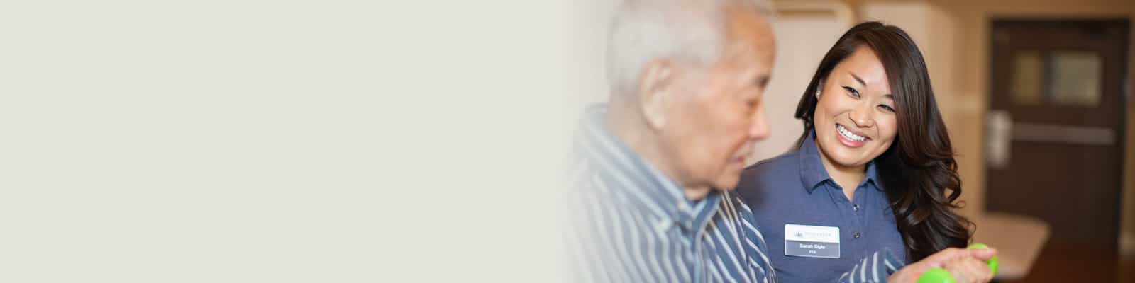 A Pine Creek rehab therapist with an elderly man in the rehab gym